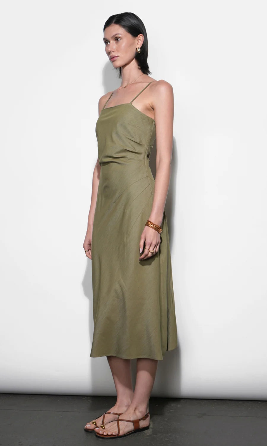 Woman wearing an olive green dress against a white background