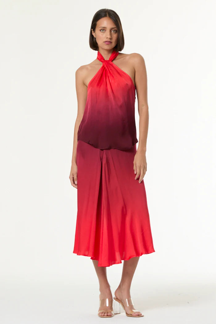Woman wearing a red halter neck dress with a gradient effect on a white background