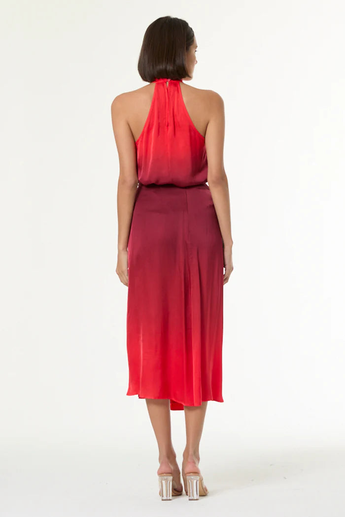 Woman wearing a red halter neck dress on a white background