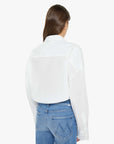 Person wearing a white shirt and blue jeans on a plain background