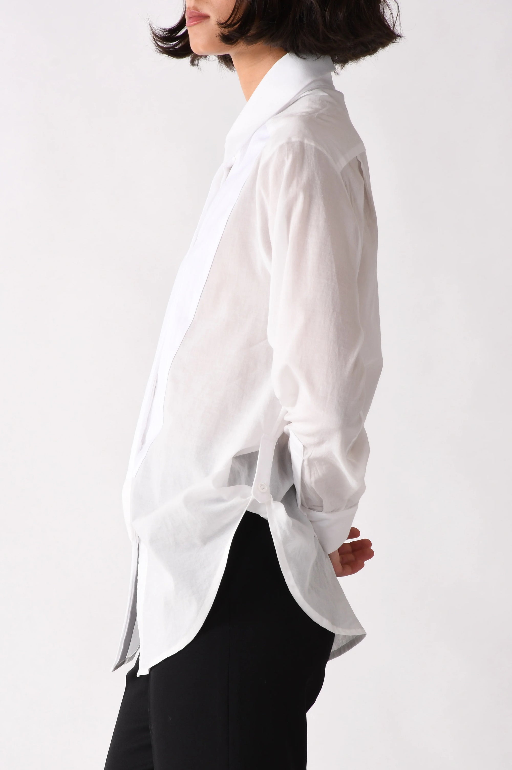 Person wearing a white shirt and black pants on a white background