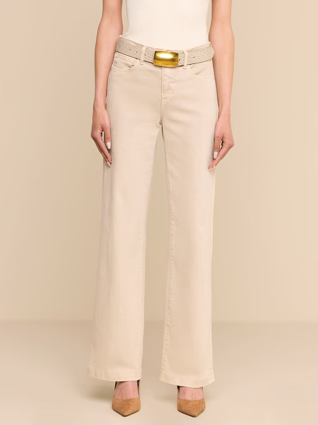 A model wearing beige wide-leg cropped pants with a matching textured belt featuring a gold buckle, styled with a white top and tan heels against a solid beige background.