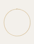 A delicate gold chain necklace with a small lobster clasp, displayed in a circular shape against a solid, warm off-white background.