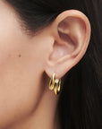 Gold hoop earring with a diamond on an ear