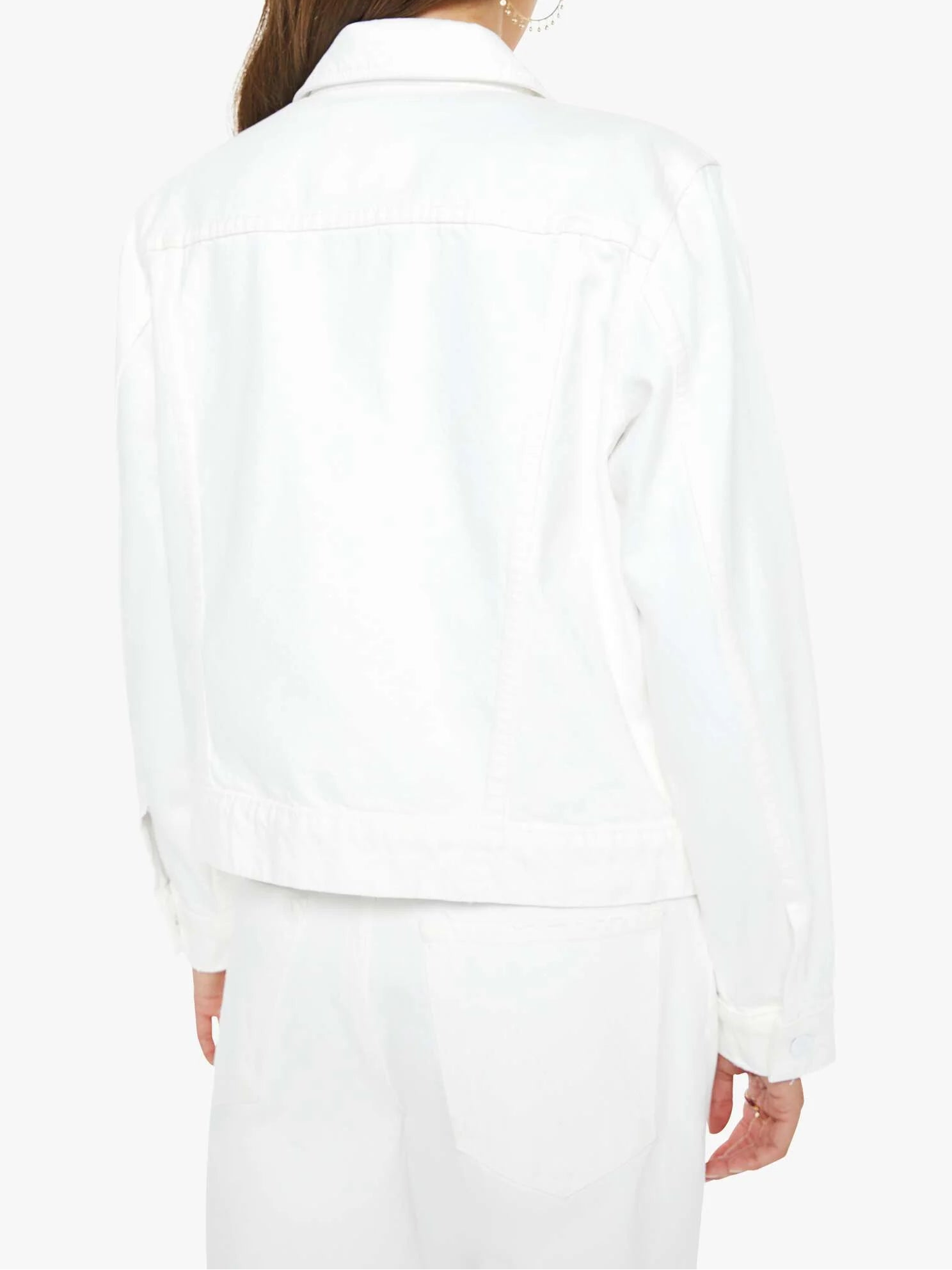 Person wearing a white suit on a plain background