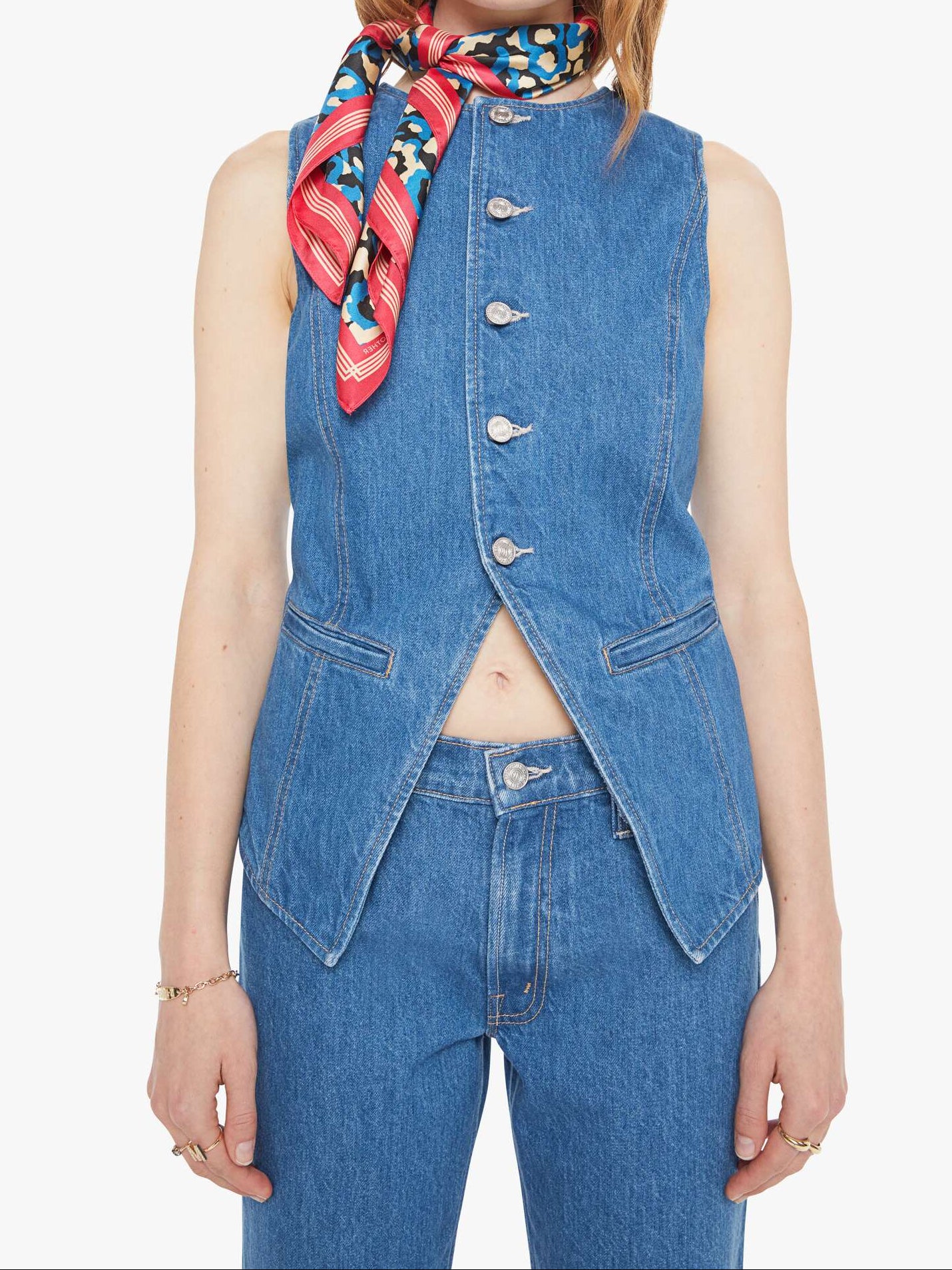 Woman wearing a denim vest and colorful scarf on a white background, front