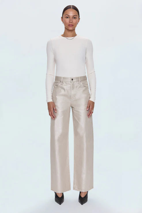 Person wearing a white long-sleeve top and beige pants on a light blue background