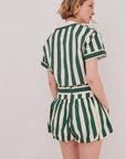 Person wearing a green and white striped outfit on a plain background