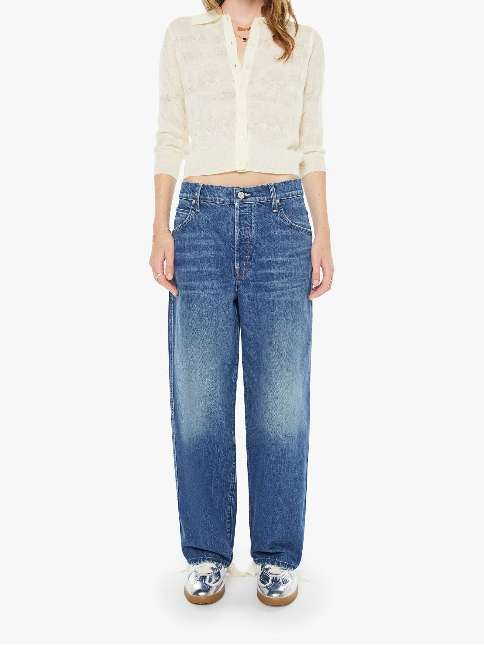 Woman wearing a white shirt and blue jeans on a white background