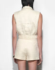 Person wearing a beige sleeveless top and shorts set on a white background