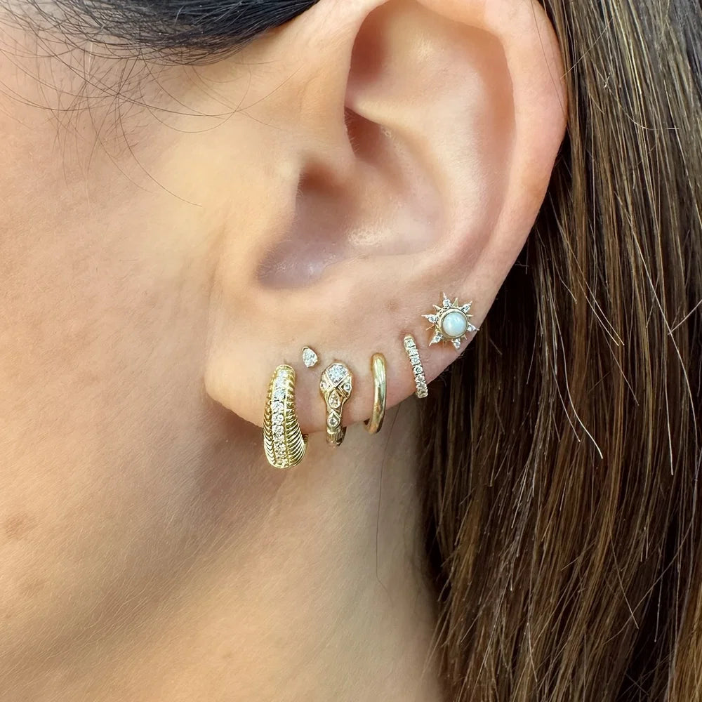 Single Copperhead Diamond Snake Huggie Hoop in model's ear paired with other earrings 