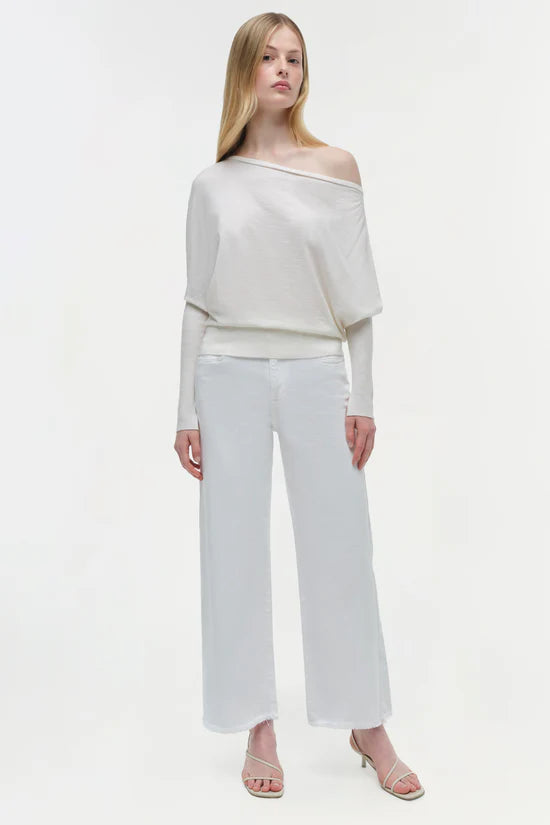 Woman wearing a white off-shoulder top and white pants on a white, background, full body
