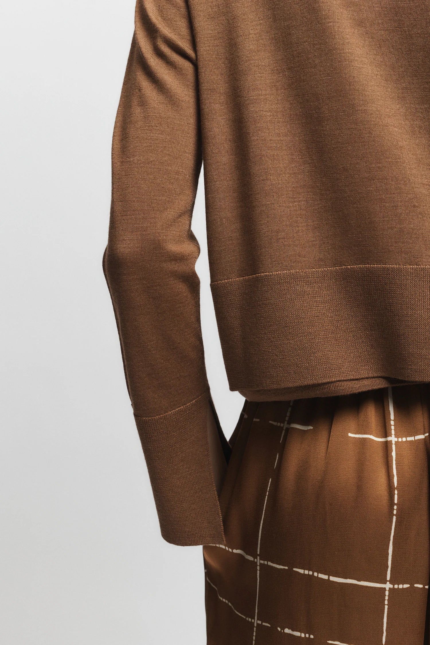 Brown long-sleeve top and pants on a light gray background, close up