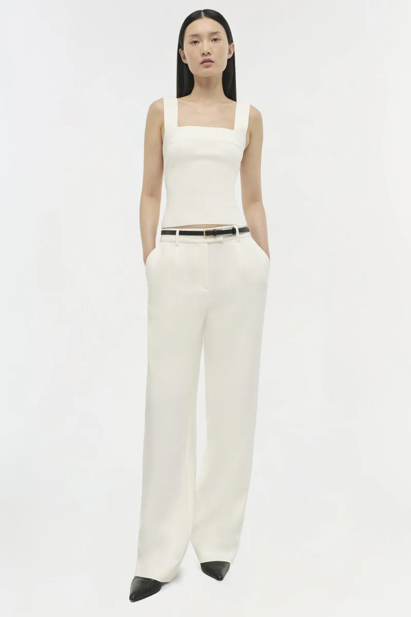 model wearing a white tank with white pants on a white background
