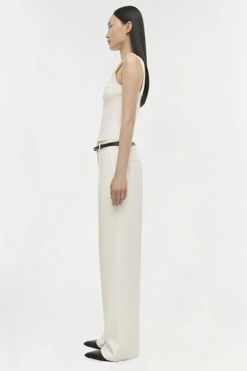 Person wearing a white sleeveless top and pants on a white background
