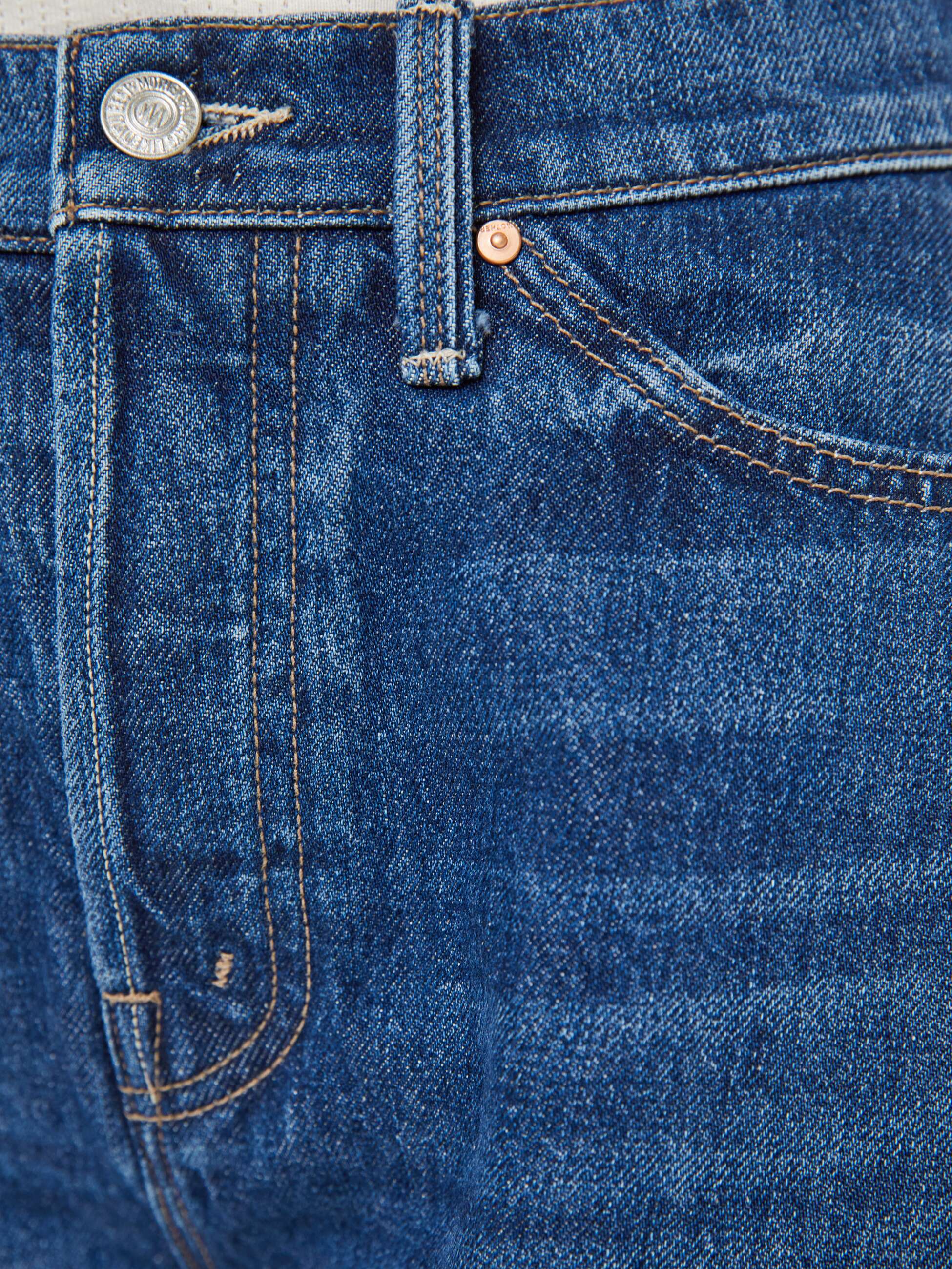 Close-up of blue denim fabric with stitching details
