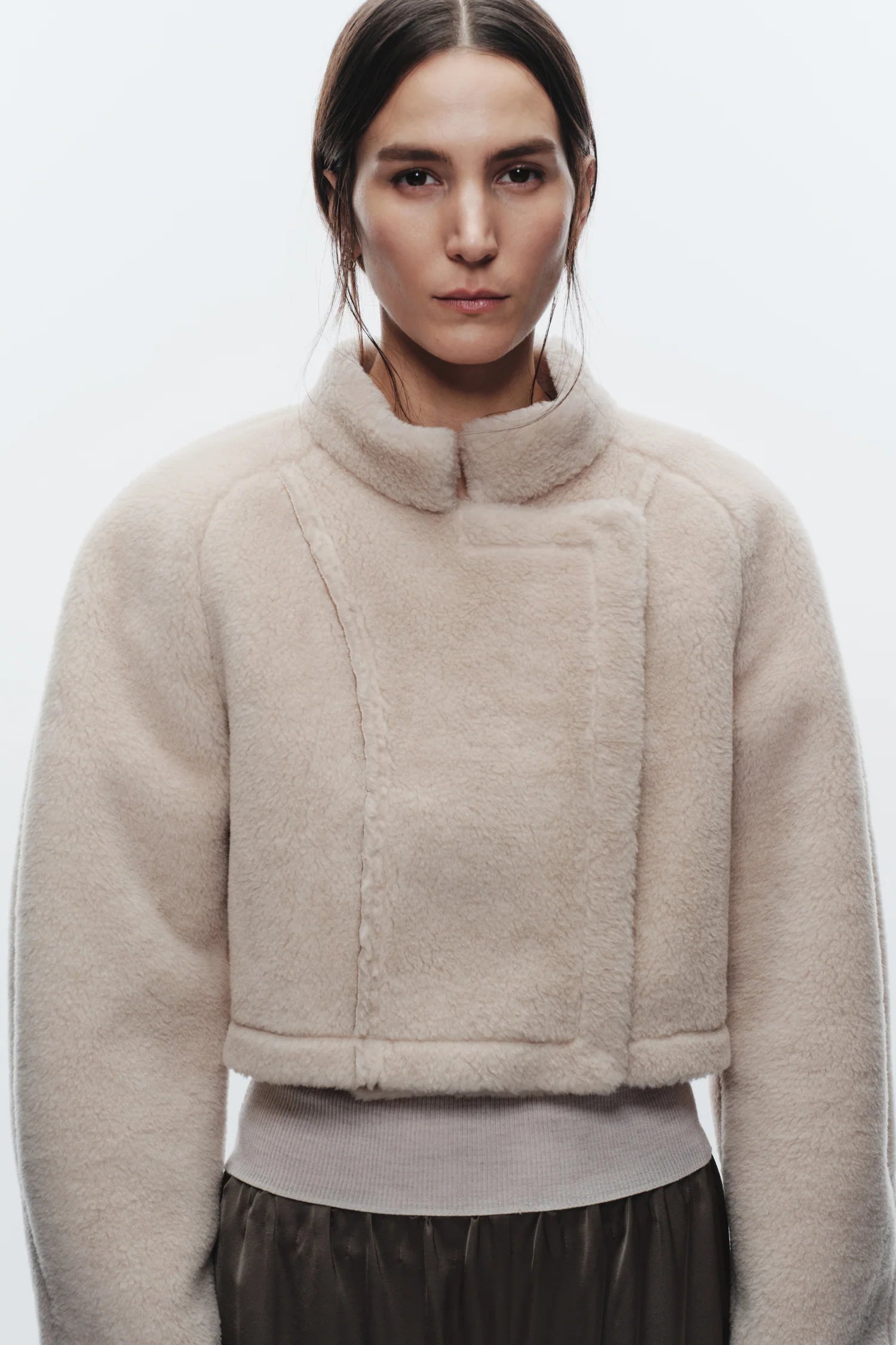 Woman wearing a beige fleece jacket on a white background