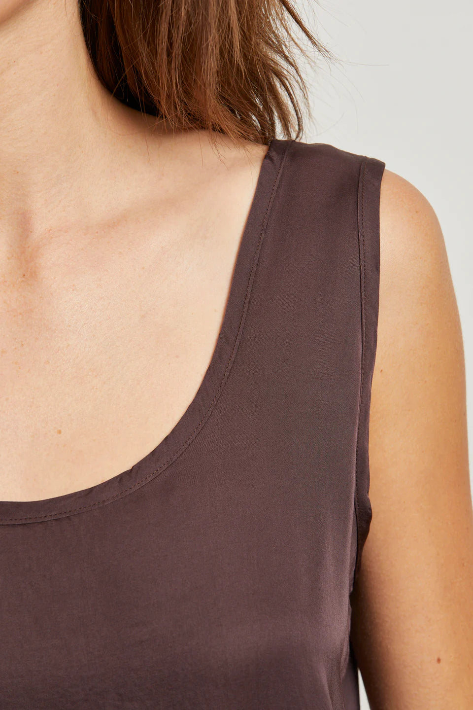 Brown tank top worn by a person on a light gray background close up view