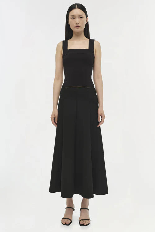 Woman wearing a black sleeveless dress on a white background