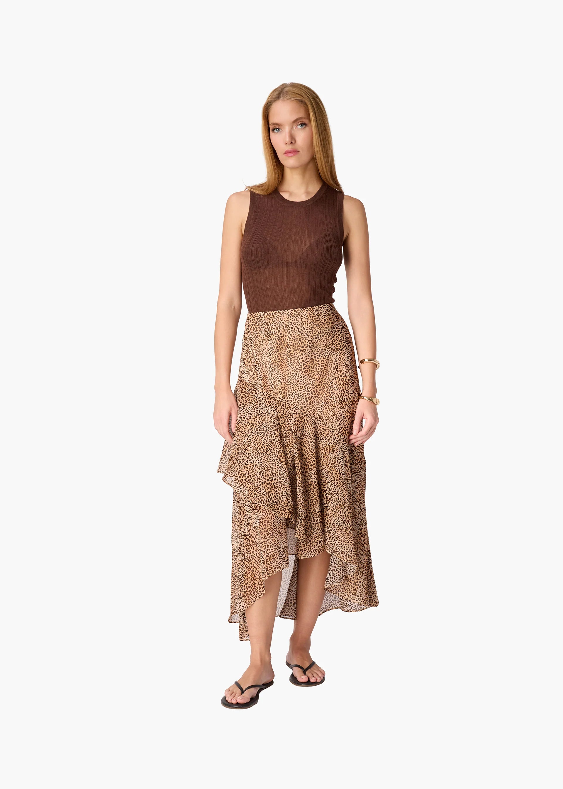 Woman wearing a brown top and patterned skirt on a white background