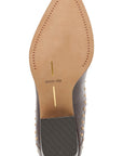 Top-down view of a brown leather shoe sole with gold-tone studs, a tan insole printed with 'dolce vita', and a black heel block on a white background.