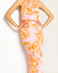 Woman wearing a floral dress with orange and pink pattern on a white background