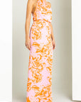 Woman wearing a floral dress with pink and orange pattern on a white background