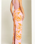 Pink and orange floral dress with a high slit on a plain background