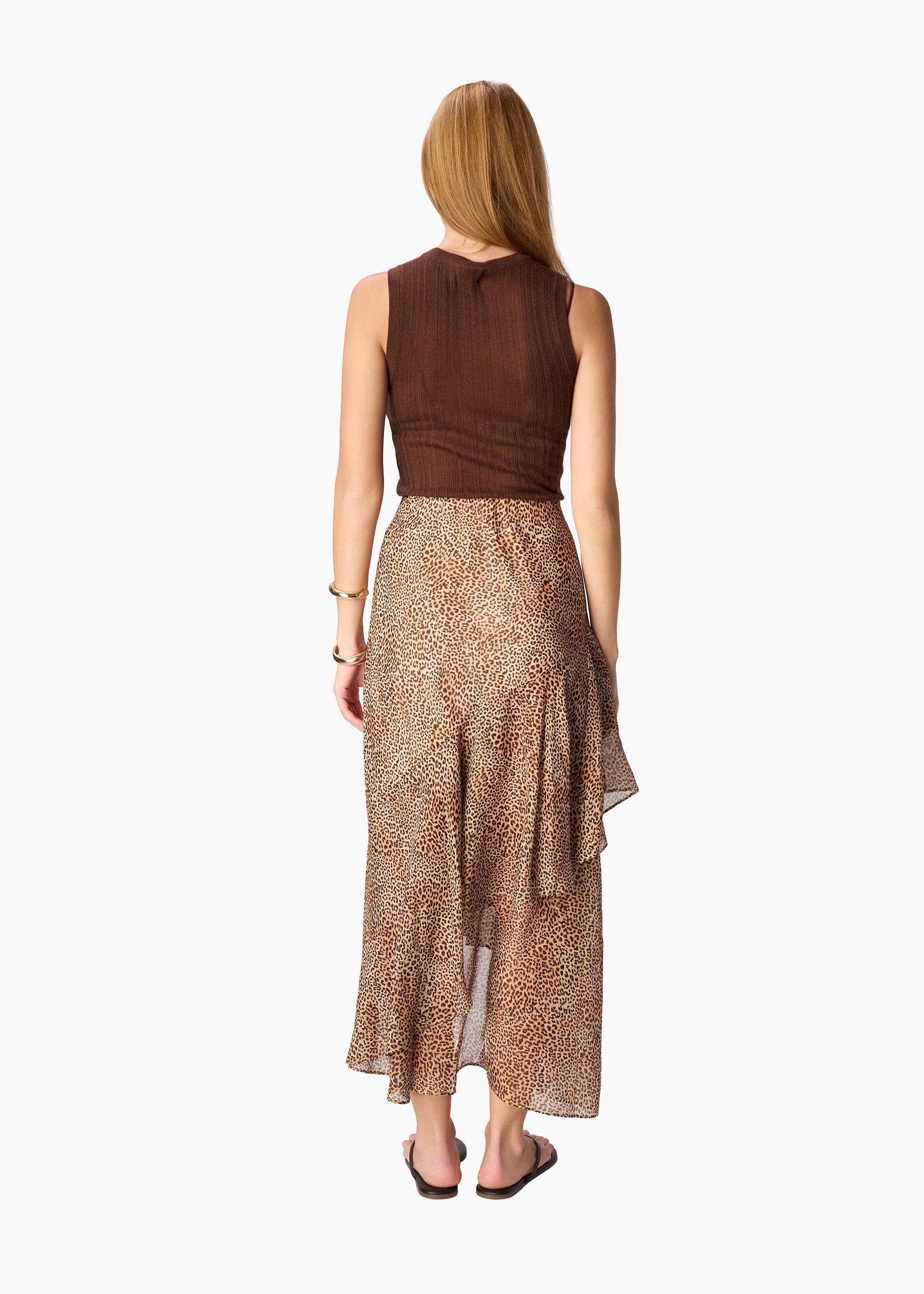 Woman wearing a brown top and leopard print skirt on a white background