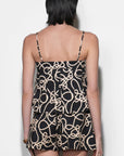 Woman wearing a black and beige patterned matching set against a white background
