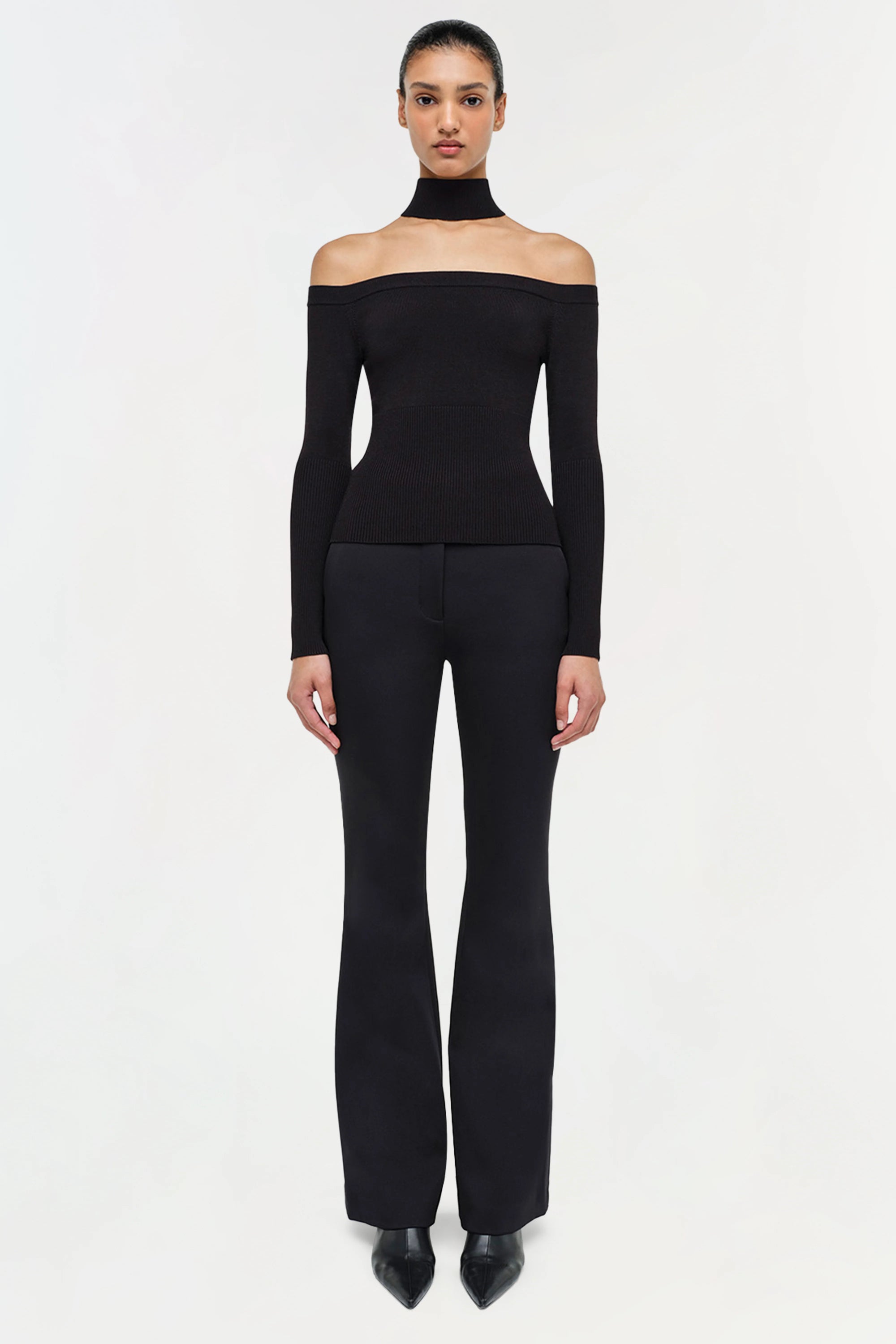 black longsleeve off shoulder lila top on a model with black jeans and a white background front