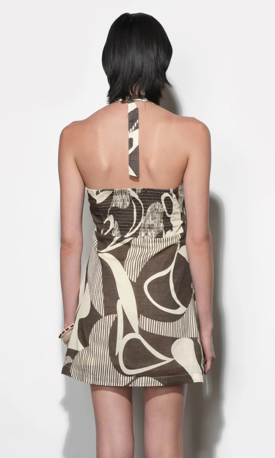 Woman wearing a patterned dress with a plain background