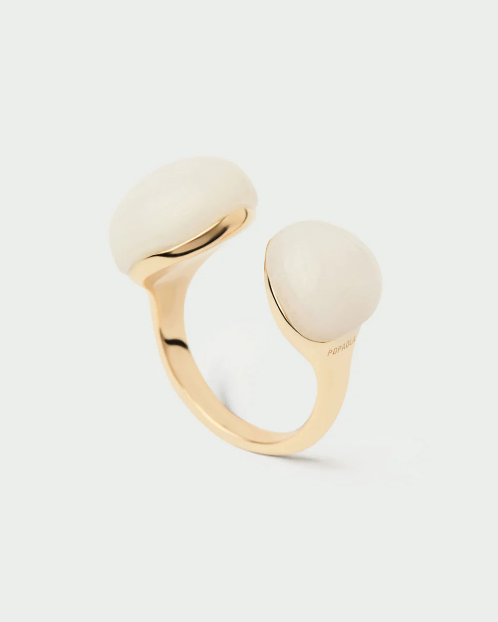 Gold ring with two quartz stones on a light gray background