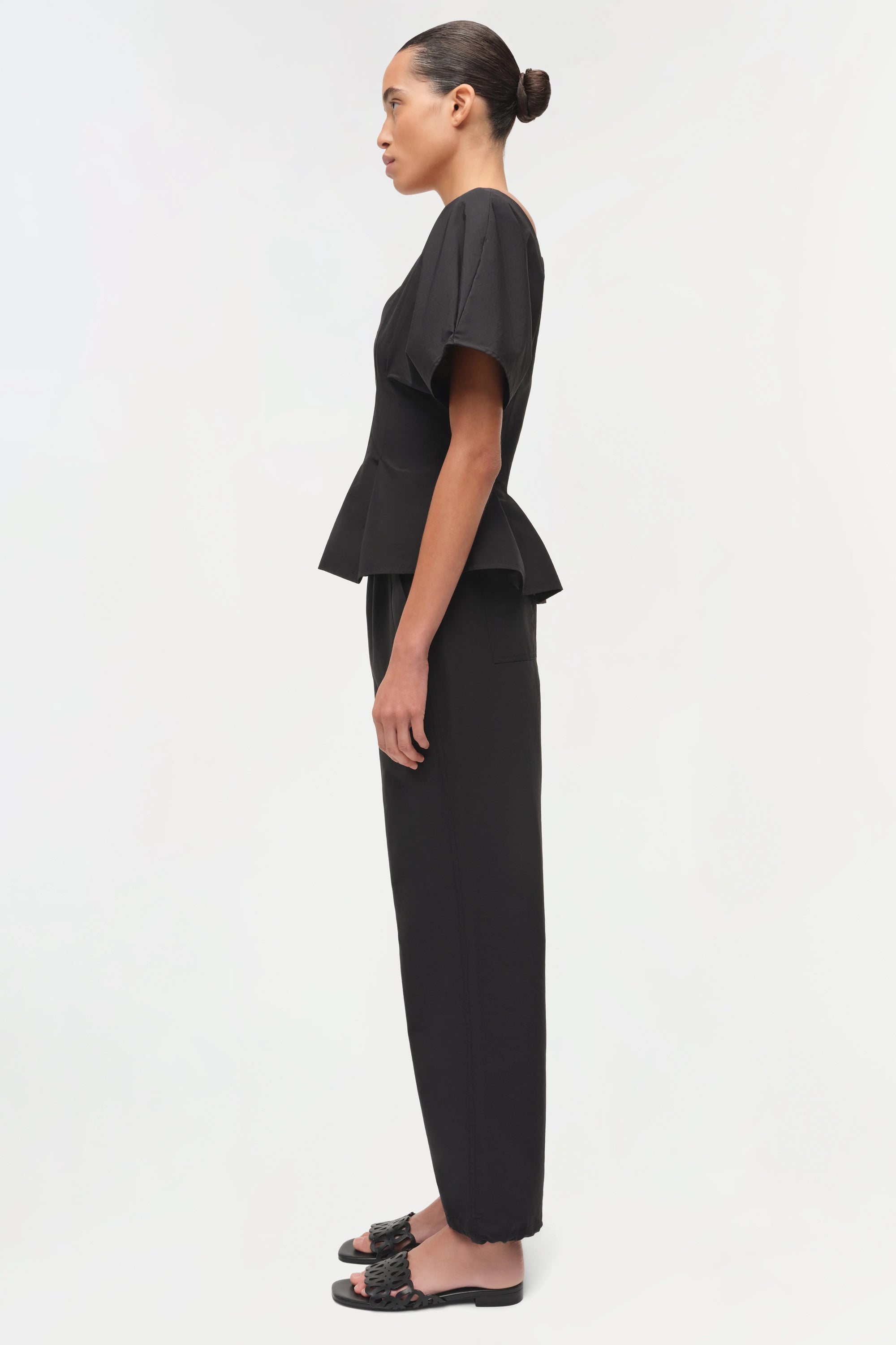 Woman wearing a black outfit on a white background