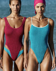 models on the beach wearing one piece bathing suits