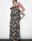 Woman wearing a black and beige patterned dress against a white background