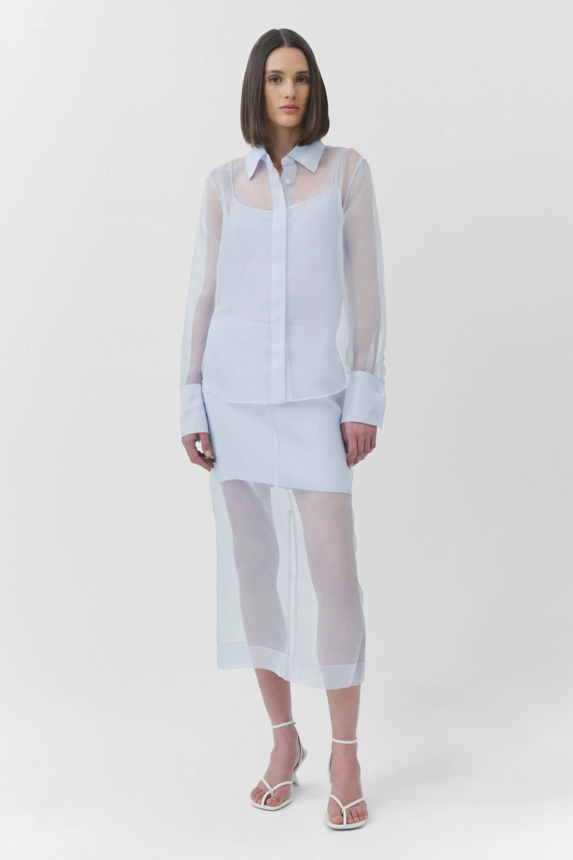 Woman wearing a light blue sheer outfit on a white background