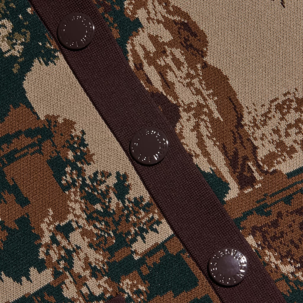 Close-up of a knit cardigan featuring a woodland camouflage pattern in brown, beige, and dark green, with a dark brown button placket and three dark brown buttons.