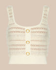 An off-white knit crop top with textured horizontal stripes and three gold-tone ring buttons down the center, displayed against a solid beige background.