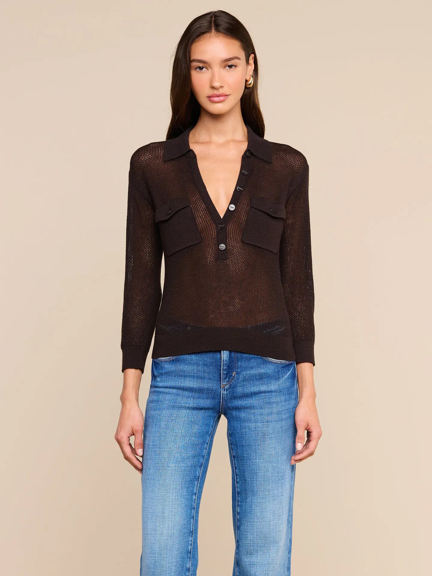 model wearing carine sweater in coffee bean with jeans on a tan background