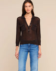 model wearing carine sweater in coffee bean with jeans on a tan background