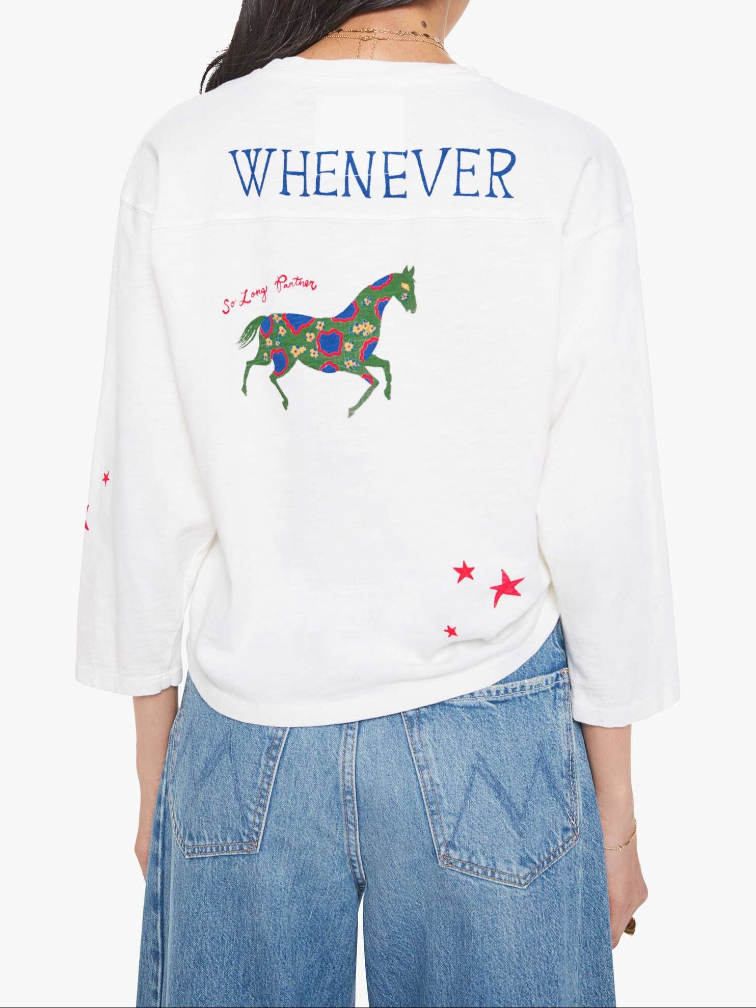 Person wearing a white sweatshirt with a colorful horse design and text on the back, standing against a white background.