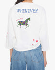 Person wearing a white sweatshirt with a colorful horse design and text on the back, standing against a white background.