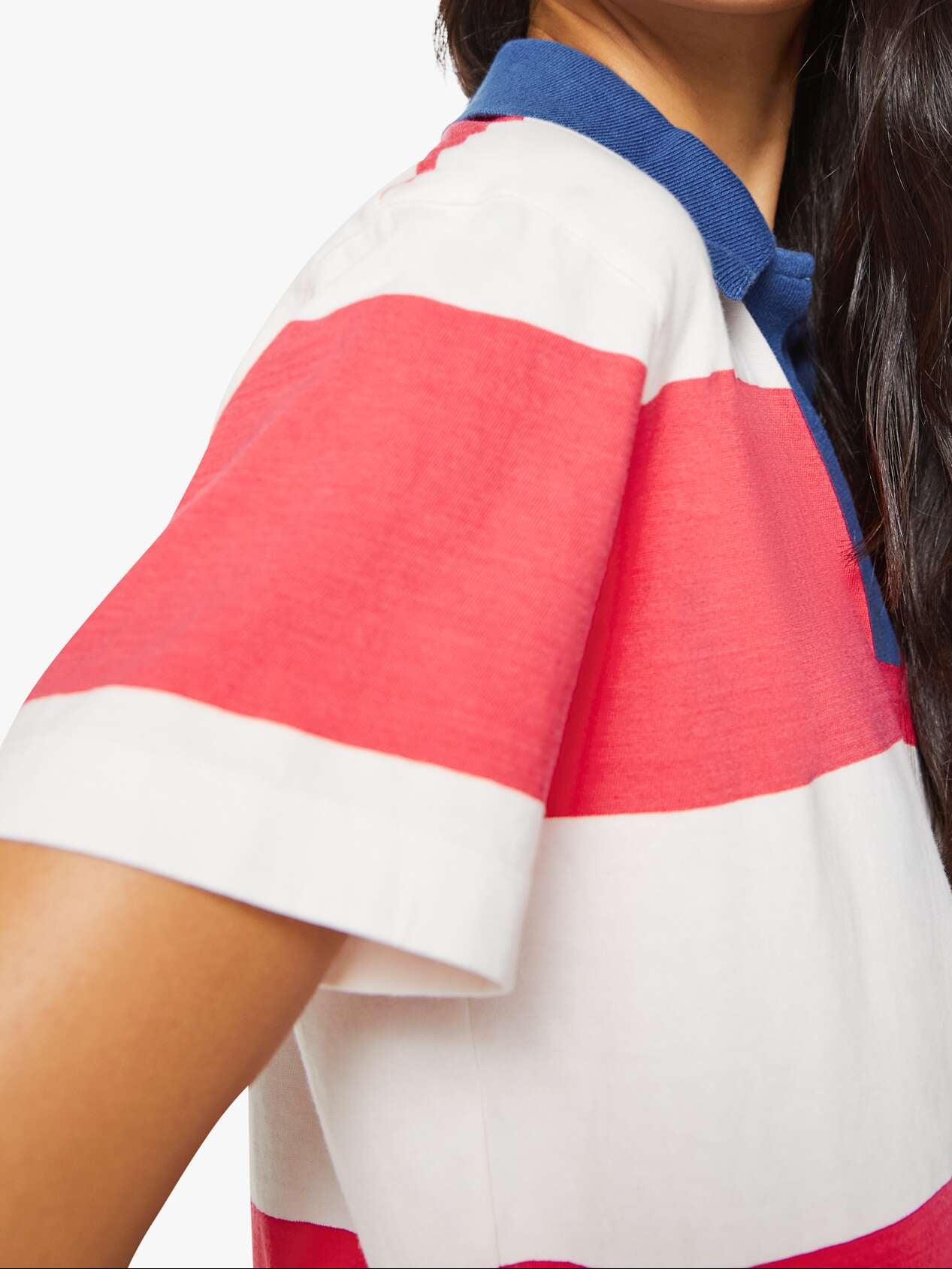 Woman wearing a colorful striped polo shirt on a white background