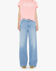 Woman wearing a pink t-shirt with text and light blue jeans on a white background
