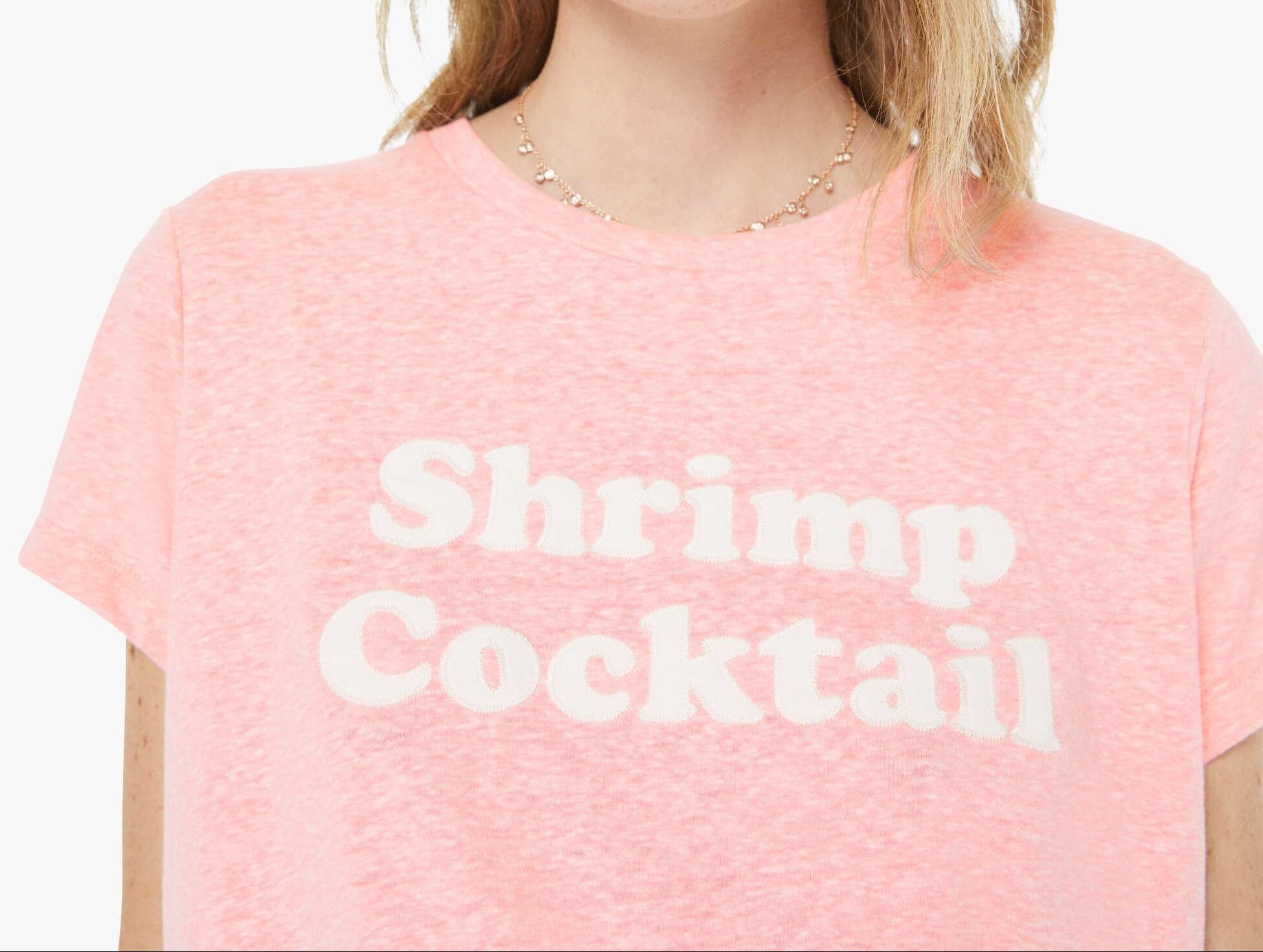 Person wearing a pink t-shirt with 'Shrimp Cocktail' text and red sunglasses on a white background