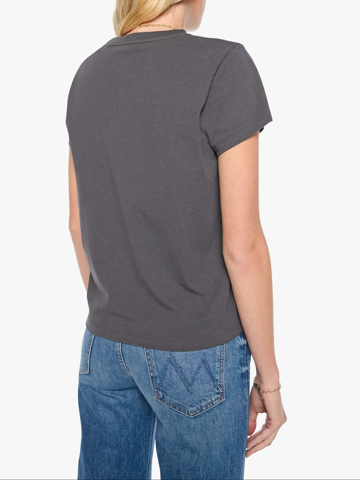 Person wearing a dark gray t-shirt and blue jeans on a white background