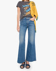 Woman wearing a graphic t-shirt, yellow jacket, and blue jeans on a white background