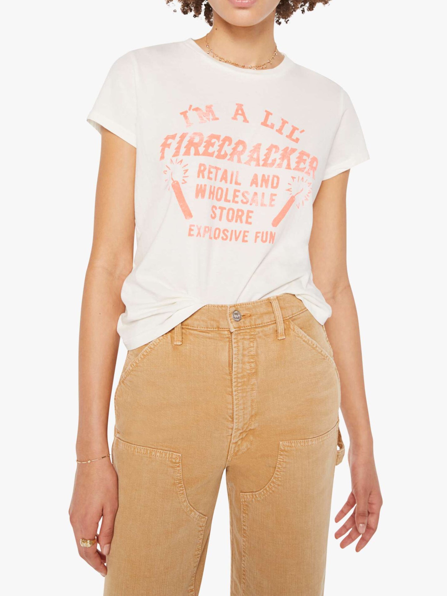 Person wearing a white t-shirt with red text and beige pants on a white background