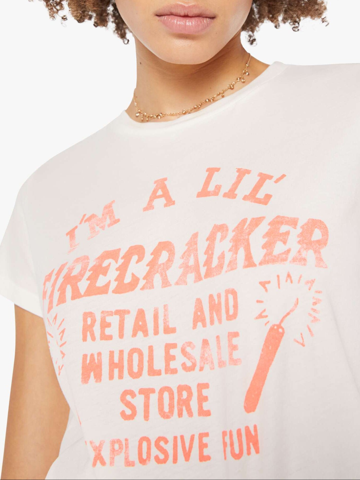 Person wearing a white t-shirt with pink text and graphics on a plain background, super close up view